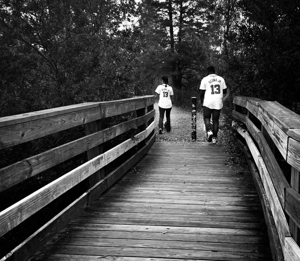 black and white art print of mixed race couple walking away in the distance in love, with Atlanta braves jerseys on, mixed race couple in love standing by the water with baseball jerseys on, atlanta, georgia braves, young caucasian male model, suit, and dress clothes, young caucasian couple with dance clothes, in love, going to dance, Nashville live music, Austin concert photography, Ryman Auditorium shows, Continental Club photography, Grand Ole Opry backstage, 6th Street live music, Music Row sessions, ACL Live Moody Theater, Bluebird Cafe performances, Antone's Nightclub, Exit/In concerts, Stubb's BBQ stage, Station Inn bluegrass, The Saxon Pub shows, Schermerhorn Symphony, Paramount Theatre Austin, Lower Broadway nightlife, South Congress music scene, Nashville recording studios, Austin City Limits tapings, SXSW festival coverage, Americana music fest, CMA Fest photography, Nashville songwriter rounds, Austin blues scene, Tennessee performing arts, Texas live music capital, musician portraits, guitar details, drum kit close-ups, stage lighting, backstage access, green room moments, soundcheck photos, artist candids, venue architecture, music festival coverage, instrument details, concert crowd shots, honky tonk performances, music row portraits, studio sessions, album cover shoots, press kit photos, tour photography, documentary music, band promotional shots, artist headshots, editorial music photos, Nashville skyline, Austin music landmarks, vintage microphones, guitar silhouettes, amp details, pedal steel guitar, fiddle player shots, banjo close-ups, mandolin details, bass guitar focus, drum solos, keyboard artist, vocal performance, music merchandise, tour bus life, meet and greet photos, fan interactions, artist interviews, music journalism, red carpet events, awards shows, Nashville fashion, Austin music style, concert atmospherics, venue exteriors, neon signs, marquee shots, street performers, buskers on Broadway, artist rehearsals, music video stills, album release parties, record stores, vintage guitars, music memorabilia, artist collaborations, songwriting sessions, music production, studio gear, mixing board details, Nashville cat musicians, Austin session players, genre-crossing, country music, rock photography, indie music scene, blues performers, jazz artists, folk singers, americana artists, alternative bands, punk shows, metal concerts, hip-hop performances, electronic music, classical concerts, opera performances, symphony shows, music festivals, outdoor stages, indoor venues, intimate shows, arena concerts, amphitheater shows, music workshops, guitar pulls, songwriter nights, music industry events, record label sessions