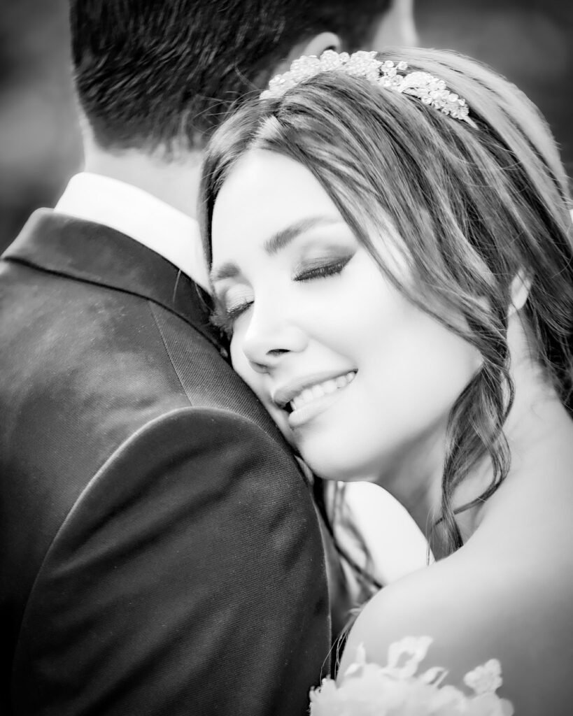 Bride resting her face on her groom's shoulders while dancing, smiling gracefully, Jacksonville wedding photographer, St. Johns River wedding, Florida beach wedding, Riverside wedding venue, San Marco wedding photos, Jacksonville Beach ceremonies, Ponte Vedra wedding, Treasury on the Plaza, River House St. Augustine, Jacksonville Beaches wedding, The White Room wedding, TPC Sawgrass wedding, Garden Club of Jacksonville, romantic sunset photos, Florida golden hour, Atlantic Beach wedding, Neptune Beach celebration, Jacksonville Arboretum photos, Downtown Jacksonville portraits, River City wedding, Ribault Club wedding, Epping Forest Yacht Club, Windsor Parke Golf Club, The Ritz-Carlton Amelia Island, Oceanfront ceremony, Spanish moss backdrop, Southern charm wedding, Jacksonville historical venues, Florida live oak trees, waterfront ceremonies, Cummer Museum gardens, The Club Continental, Jacksonville Golf & Country Club, maritime details, Jacksonville skyline photos, First Coast wedding, Northeast Florida wedding, coastal elegance, tropical florals, palm tree backdrop, destination wedding Jacksonville, intimate beach ceremony, luxury venue photography, Villa Blanca wedding, Jacksonville candid moments, wedding photojournalism, bridal party beach photos, Jacksonville engagement session, River & Post rooftop, black and white moments, emotional first look, MOSH rooftop wedding, Unity Plaza events, Friday Musicale venue, Jacksonville University, plantation wedding photos, natural light portraits, sunset beach portraits, romantic garden ceremony, The Glass Factory wedding, Sweet Pete's Candy wedding, authentic moments, Jacksonville architecture, historic Springfield photos, Riverside romance, Avondale wedding, vintage Jacksonville, metropolitan photos, cultural venues, Marineland wedding, The Manor at 12 Oaks, The Mansion at Glen Cove, Jacksonville Botanical Gardens, Jacksonville Zoo wedding, military wedding Jacksonville, NAS JAX celebration, timeless portraits, emotional storytelling, creative compositions, artistic wedding photos, film photography style, traditional southern wedding, modern Jacksonville wedding, urban wedding photos, classic bride portraits, documentary approach, bride and groom portraits, getting ready moments, wedding day details, wedding party photos, ceremony coverage, reception moments, dance floor candids, wedding rings macro, bridal accessories, venue details, wedding decor shots, architectural elements, dramatic lighting, romantic poses, authentic emotions, family formal photos, morning preparation, evening celebration, golden light portraits, destination details, venue exterior shots