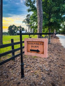 Photography of Magnolia Barn entrance and directional signage at Pine Knoll Farm Event Center in Appling Georgia