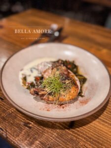 Professional Food photography - picture of gourmet plated chicken dish in a restaurant environment with a prepared cocktail